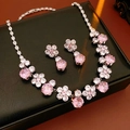 Detailed macro view of pink zircon flower necklace and matching drop earrings on black leather - Pink (2-Piece Set)