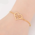 Detail of gold heart-shaped pulse bracelet on wrist showing fine chain and unique charm - Heart EKG / Gold