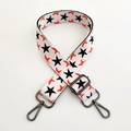 Close-up of adjustable wide shoulder strap with black stars and gunmetal swivel hooks - White Base Black Star Gunmetal Buckle