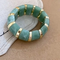 Detailed close-up of emerald marble texture acrylic resin blocks with golden metal spacers - Green Marble