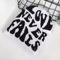 Black and white knit beanie featuring Love Never Fails jacquard text pattern - One Size / White