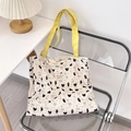 Close-up of cute kitty canvas tote bag featuring yellow straps and artistic heart patterns - Black Cat & Dog