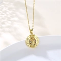Macro detail of gold cobra coin pendant with colorful zircon stones on white tray - Gold