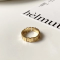 Macro-opname van vergulde open ring met tandwielstructuur en ingelegde zirkoniasteen - Goud-Rechthoekig Blok