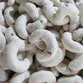 Pile of crescent-shaped plush pet pillows featuring white fabric and pink cherry embroidery - White