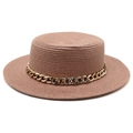 Detailed close-up of brown flat top straw hat with textured weave and gold chain detail - Deep Pink