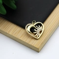 Macro view of 18K gold plated heart pendant with pavé set zircon sun and moon motifs - Heart Sun Moon Style
