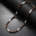 Detail showing coconut shell beads with silver lobster clasp on a dark display stand - White Stone