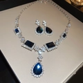 Dettaglio di un set di gioielli in argento con gemme blu scuro e cristalli bianchi - Blu