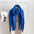 Thick blue cashmere-feel winter scarf with long tassels draped on a beige coat - Klein Blue