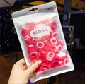 Detail of colorful elastic hair bands in a transparent zip bag held by hand - Pink (Approx. 50Pcs)