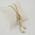 Detail of gold trapezoid pendant with white crystals on a white display pillow - Irregular Trapezoid Style (ZG210) / Gold