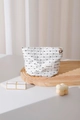 Close-up of polka dot cosmetic bag featuring a golden flower zipper pull on a wooden stand - Black Polka Dot Small Size