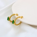 Detail of gold C-shaped twisted earrings featuring rectangular green emerald zircon - Gold/Green Zirconia