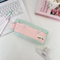 Close-up of mint green and pink canvas pencil case with heart buttons on white desk - Fresh Green