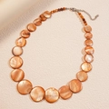 Detail of beaded shell necklace with orange shell discs and dark red beads - Brown