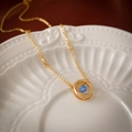 Nahaufnahme der goldenen geometrischen Kette mit blauem Zirkonia und Kristallakzenten - Blau Zirkonia Halskette
