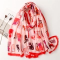 Roze sjaal met cartoon kattenprints en rode randen op witte tafel met een tijdschrift - Roze