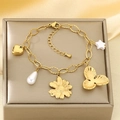 Dettaglio di un bracciale dorato con ciondoli a cuore, perla e fiori su scatola espositiva - Stile Margherita Perla Stella (KB207987-SXSJ)