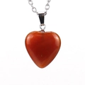 Macro shot of faceted heart-shaped carnelian stone pendant on a silver metal chain - Red Agate