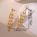 Long gold 18K plated stainless steel teardrop earrings on a minimalist white display - Gold