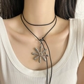 Close-up of a large silver flower pendant on a minimalist black cord necklace - Large Silver Flower