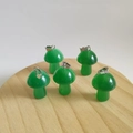 Five green natural stone mushroom pendants with metal clasps on a wooden base - Synthetic Green Cat Eye