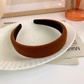 Detailed texture of a wide vintage dark brown velvet headband on a decorative plate - Tan
