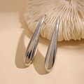 Makrodetail der polierten silbernen Tropfenohrringe mit spiegelndem Metallfinish - Silber (Silberstift)