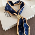 Detail of navy blue paisley silk scarf with gold wave-textured metal ring on vintage book - Blue Paisley
