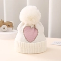 Detail of baby knitted hat with pink heart jacquard and white faux fur pompom - One Size 0-12 Months / White