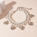 Detail van de dubbellaagse ketting met imitatieparels en zilveren hartvormige hangers - Ketting-Zilveren Hart