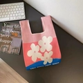 Dettaglio della borsa in maglia tricolore con motivi floreali e base blu a contrasto - Fiori Rosa