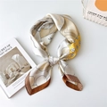 Elegant square silk scarf with yellow and brown geometric floral print in a bow tie knot - New Crane in Cloud Yellow Brown