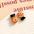 Macro shot of orange and white glass fish charms on a textured white jewelry tray - 3D Color Matching Fish / Orange White and Black