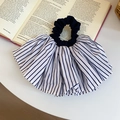 Detailed view of large pleated blue and white striped fabric scrunchie on open book - Pleated Scrunchie / White Striped
