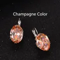 Elegant champagne oval cubic zirconia earrings with silver hooks on black surface - Champagne