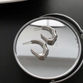 Minimalist silver fluid-shaped stainless steel heart earrings on a reflective mirror - Silver