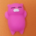 Pink silicone cat-shaped stress relief squishy toy on a textured orange surface - Rose Red Cat