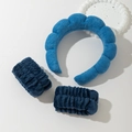 Close-up of sky blue sponge headband and matching navy plush wristbands on a tray - Royal Blue Headband And Wristbands Set