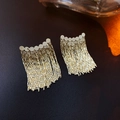 Macro detail of golden round sequin earrings with cascading metal chain tassels on leather - Disc Tassel Style / Gold