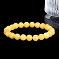 Polished yellow gemstone beaded stretch bracelet with translucent finish on black background - Amber Color Stone