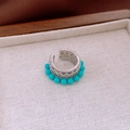 Detailopname van een vintage zilveren oormanchet met blauwe zirkoon kralen tray - Holle Ronde Ear Cuff / Zilveren Basis Hemelsblauwe Kralen