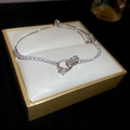 Close-up of zircon knot bracelet with heart pendant in a premium jewelry gift box - Silver