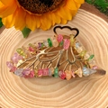 Detailed view of butterfly hair claw with natural crystal stones on a wooden background - Colorful Quartz Gold Butterfly