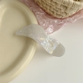 Dettaglio di un fermaglio per capelli in acetato bianco perla su un piatto di ceramica - Artiglio Per Capelli Ala Iridescente / Sirena Perlata - Stile Ala