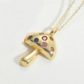Détail macro du collier pendentif champignon doré avec pierres de zircone colorées - Champignon