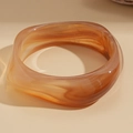 Macro shot of wide acrylic resin bangle with amber marble texture and smooth finish - Round Amber Marble Acrylic Bangle (Coffee)