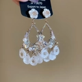 Dettaglio di orecchini a fiori in cristallo con petali in resina e perle a goccia - Stile Nappa con Strass e Fiori Bianchi / Bianco