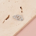 Macro shot of silver stainless steel handcuff pendants on a natural stone background - Steel